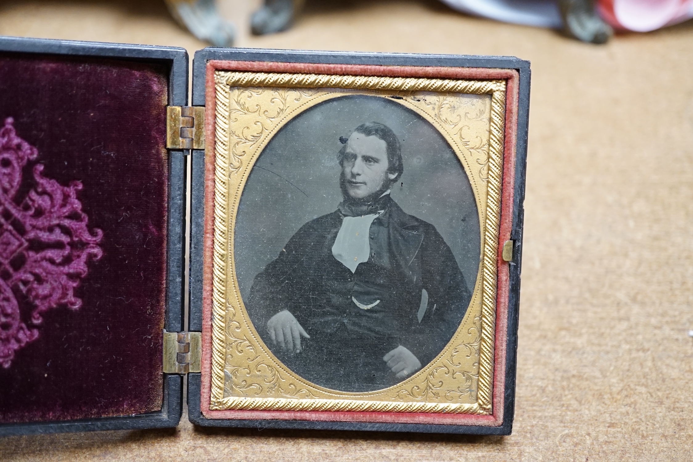 A mid Victorian ambrotype photograph of a gentleman, housed in an original pressed bois durci fireman frame, 9.5cm high. Condition - good